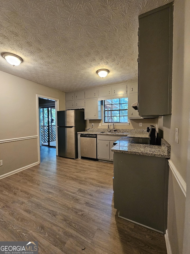 kitchen featuring hardwood / wood-style floors, a healthy amount of sunlight, and appliances with stainless steel finishes