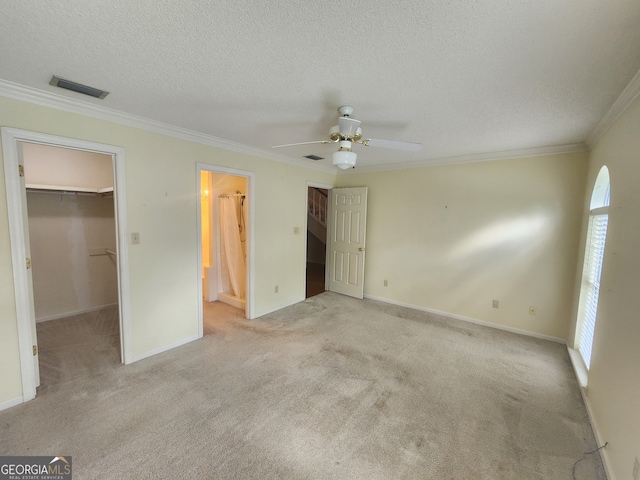 unfurnished bedroom with ceiling fan, a walk in closet, light colored carpet, and a closet