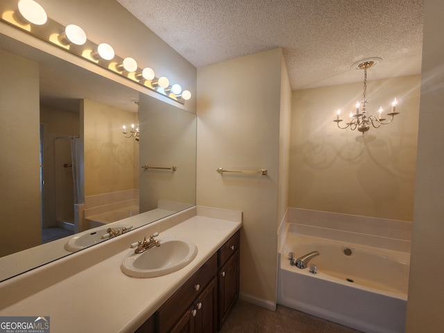 bathroom with a textured ceiling, a bathtub, vanity, and an inviting chandelier