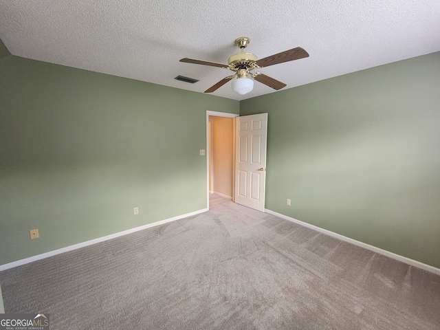 carpeted empty room with ceiling fan and a textured ceiling