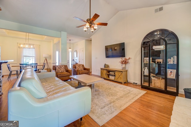 living room with ceiling fan, high vaulted ceiling, and wood-type flooring