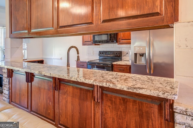 kitchen featuring black appliances, sink, light stone counters, and backsplash