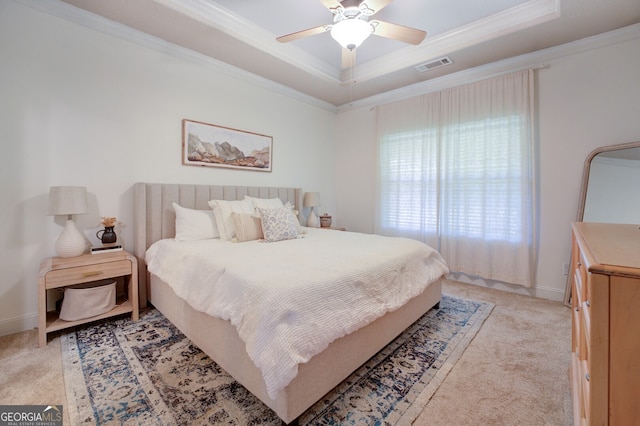 carpeted bedroom with ceiling fan, a raised ceiling, and ornamental molding