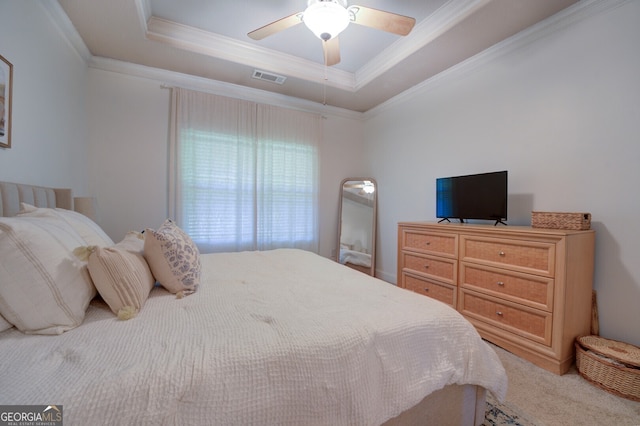 bedroom featuring a tray ceiling, carpet flooring, ornamental molding, and ceiling fan