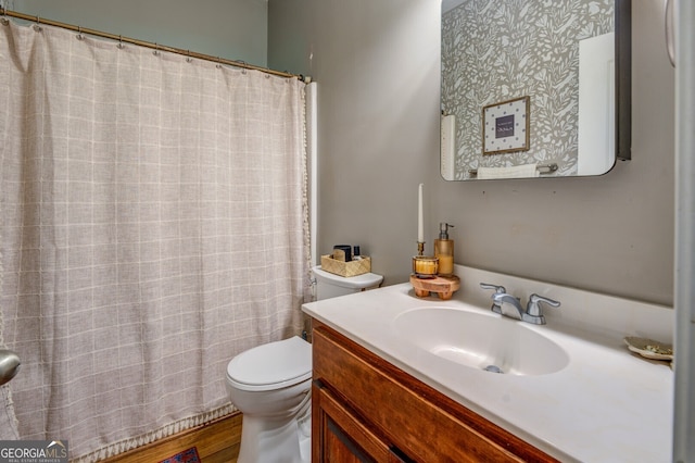 bathroom with hardwood / wood-style flooring, vanity, and toilet