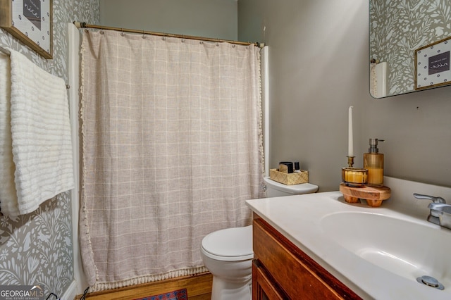 bathroom with toilet, vanity, and hardwood / wood-style floors