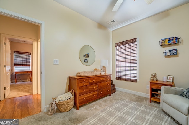 living area featuring ceiling fan and carpet