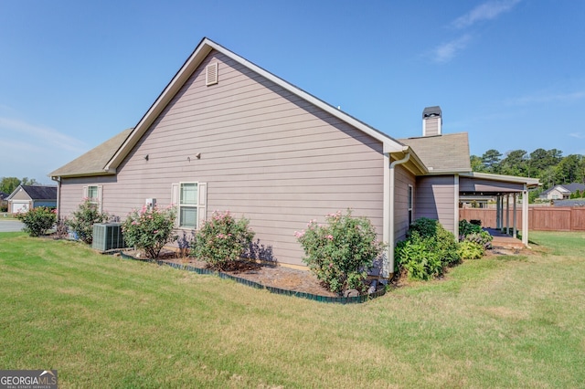 view of side of property featuring central AC and a lawn