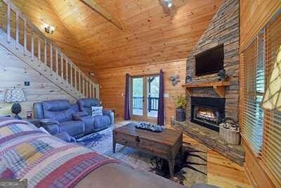 living room with wood ceiling, high vaulted ceiling, wood-type flooring, wood walls, and a fireplace