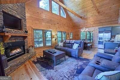 living room with high vaulted ceiling, hardwood / wood-style flooring, a healthy amount of sunlight, and wooden ceiling