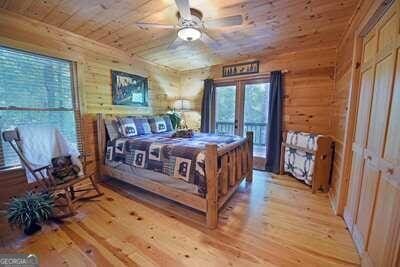 bedroom featuring ceiling fan, wood walls, wood ceiling, and light hardwood / wood-style floors