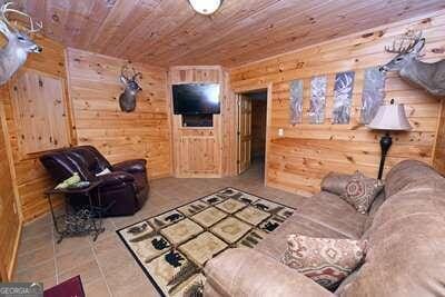 tiled living room with wooden walls and wood ceiling