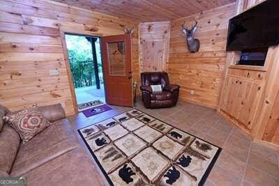 living room with wood walls, tile patterned flooring, and wood ceiling