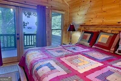 bedroom with wood walls and access to outside