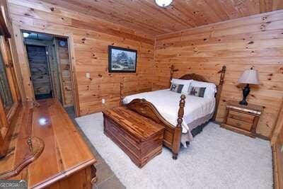 bedroom with wooden walls and wood ceiling