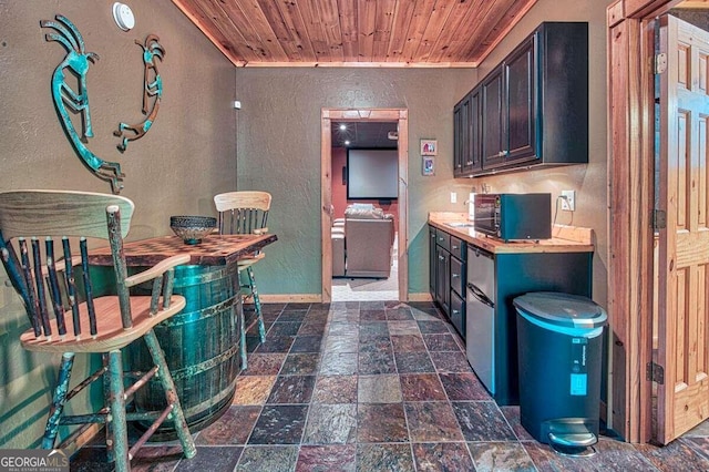 kitchen featuring dark brown cabinets, wooden ceiling, ornamental molding, and wooden counters