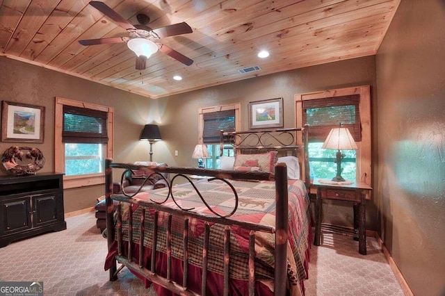 bedroom featuring ceiling fan, wooden ceiling, light carpet, and multiple windows