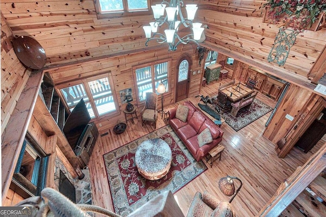 living room featuring hardwood / wood-style floors, high vaulted ceiling, and a chandelier