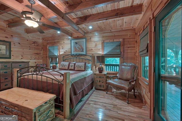 bedroom featuring beam ceiling, wooden walls, wooden ceiling, and light wood-type flooring