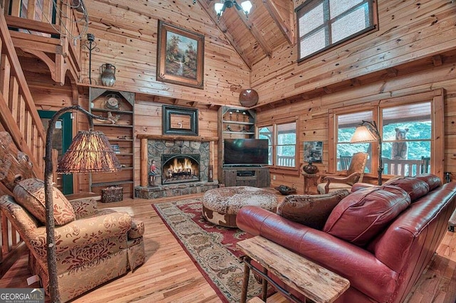 living room featuring wood ceiling, wooden walls, wood-type flooring, high vaulted ceiling, and a fireplace