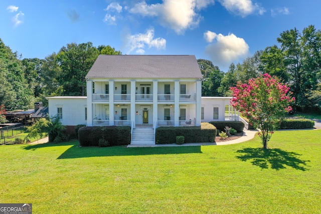 view of front facade featuring a balcony and a front yard