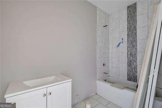 bathroom featuring tile patterned flooring, vanity, and tiled shower / bath