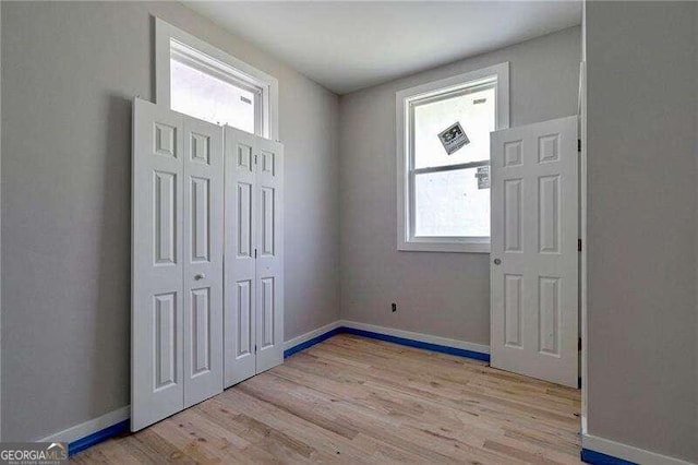 unfurnished bedroom featuring light hardwood / wood-style floors and a closet