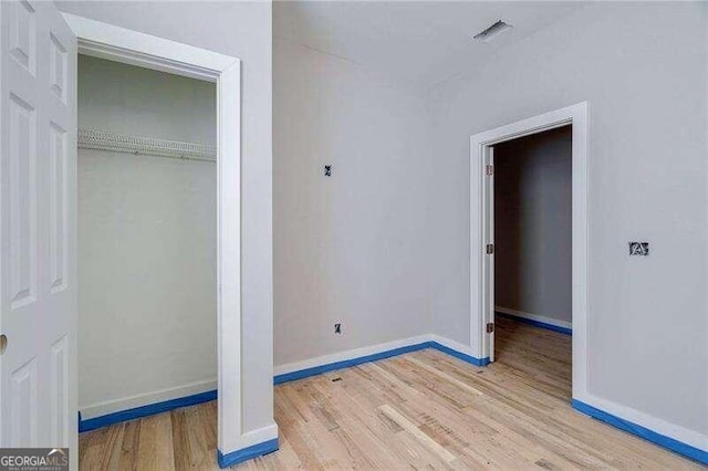 unfurnished bedroom featuring a closet and light hardwood / wood-style floors