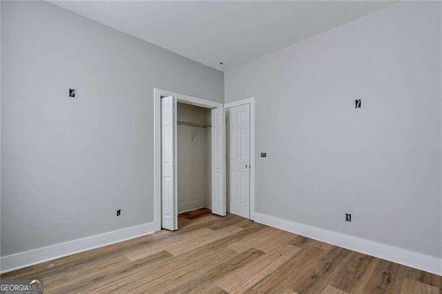 unfurnished bedroom with light wood-type flooring and a closet