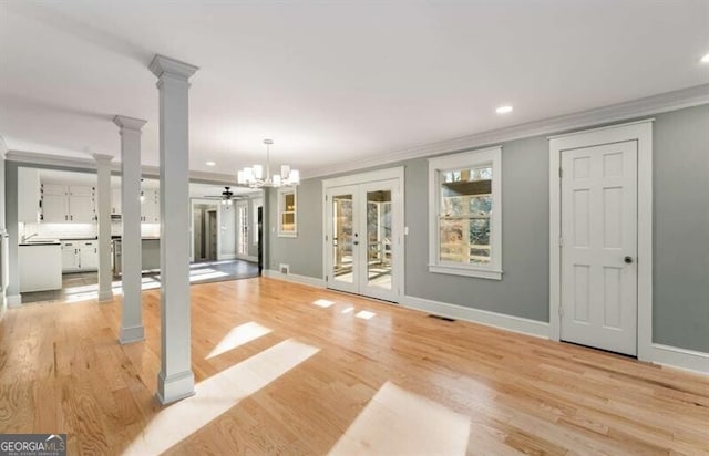 interior space with visible vents, ornamental molding, decorative columns, and light wood-style floors