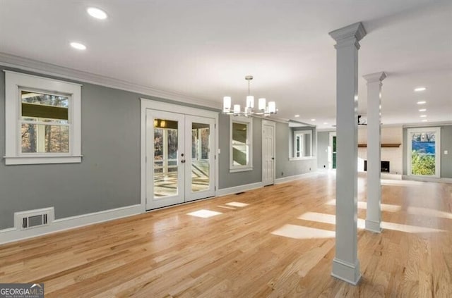 unfurnished dining area with ornamental molding, french doors, light wood-type flooring, and visible vents