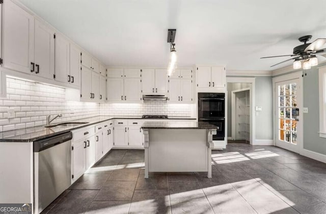 kitchen featuring dobule oven black, a sink, white cabinets, stainless steel dishwasher, and decorative backsplash