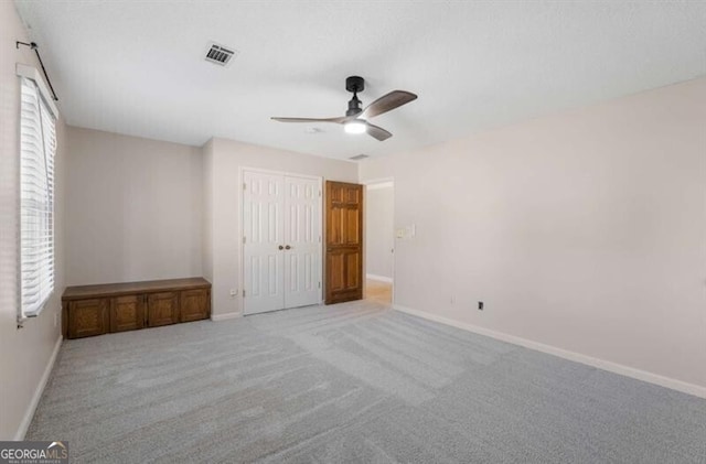 unfurnished bedroom with carpet flooring, a closet, visible vents, and baseboards