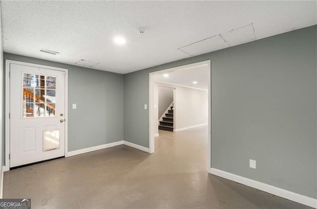 interior space featuring visible vents, concrete floors, stairway, and baseboards