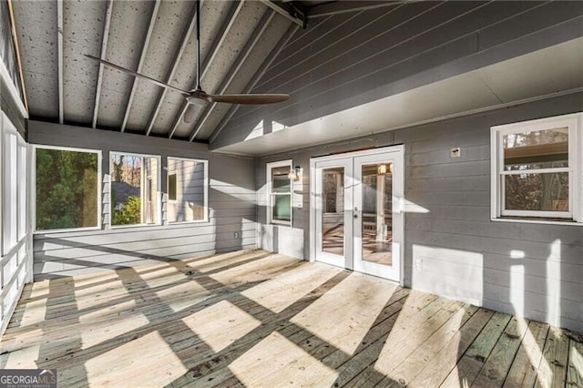 unfurnished sunroom featuring ceiling fan, french doors, and vaulted ceiling with beams