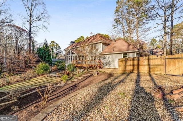 rear view of house with a gate, fence, and a wooden deck