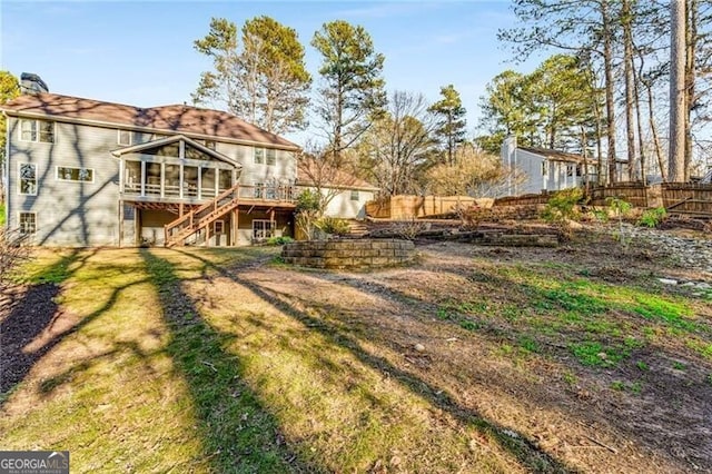 view of yard with fence, a deck, and stairs