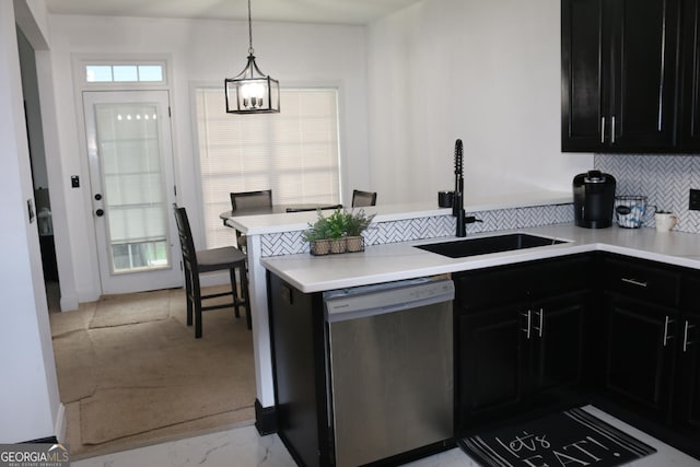 kitchen with an inviting chandelier, dishwasher, pendant lighting, tasteful backsplash, and sink