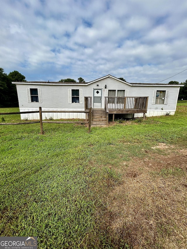 manufactured / mobile home with a front yard and a wooden deck