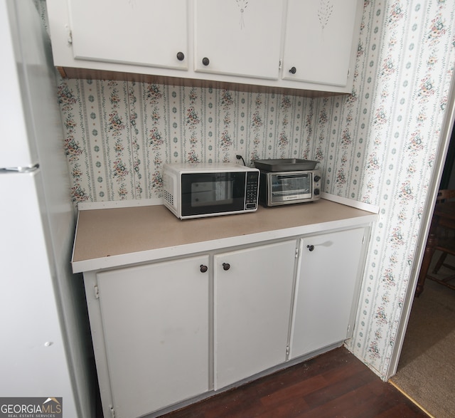 kitchen featuring white cabinets, dark hardwood / wood-style floors, and white fridge