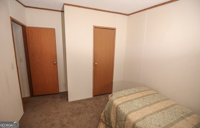 carpeted bedroom with ornamental molding and a textured ceiling