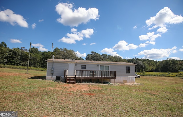rear view of property featuring a yard, central air condition unit, and a wooden deck