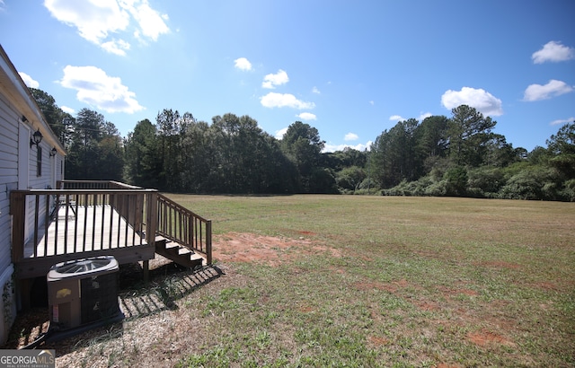 view of yard with a wooden deck and central air condition unit