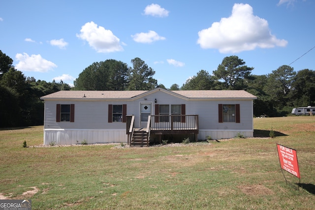 manufactured / mobile home with a deck and a front lawn