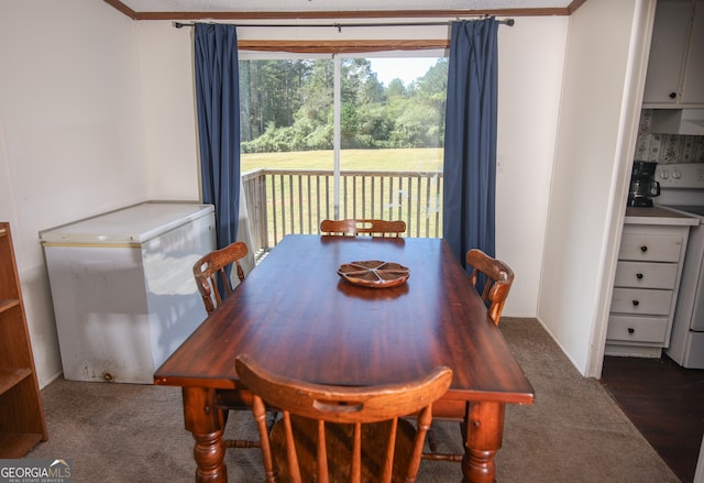 dining area with ornamental molding and dark hardwood / wood-style flooring