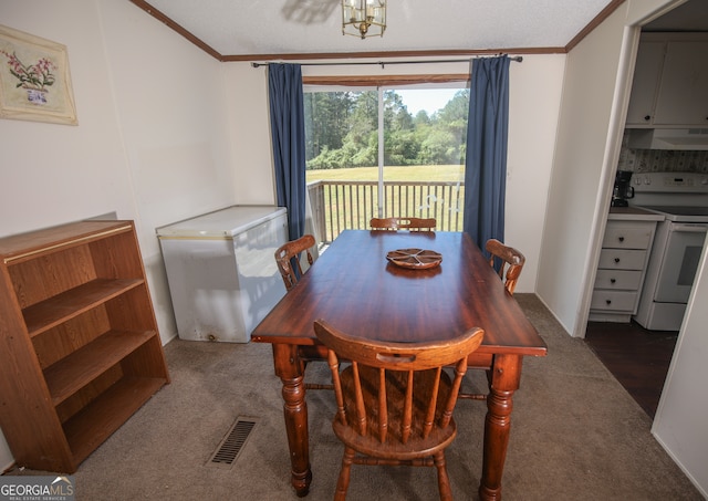 dining room featuring ornamental molding and dark carpet