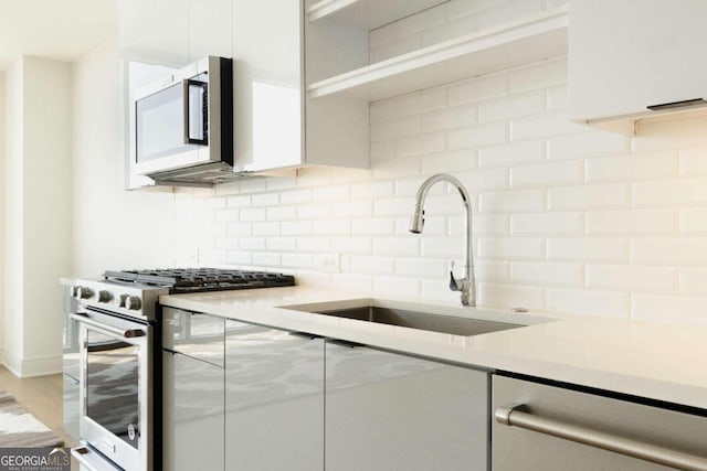 kitchen with sink, tasteful backsplash, and luxury stove