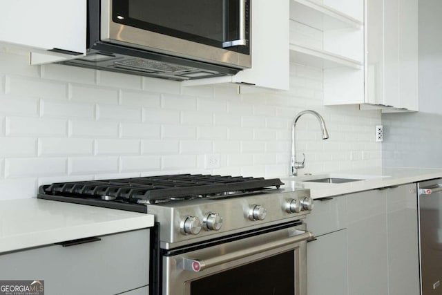 kitchen with white cabinetry, tasteful backsplash, sink, and stainless steel appliances