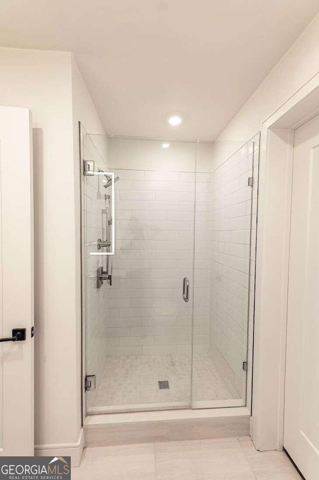 bathroom featuring an enclosed shower and tile patterned floors