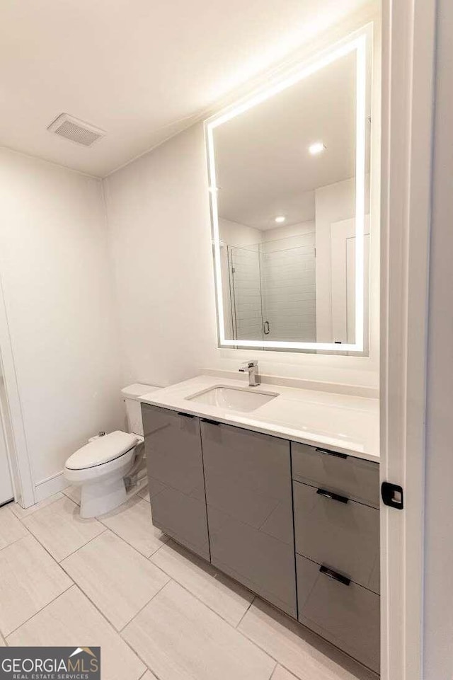 bathroom with vanity, toilet, and tile patterned flooring